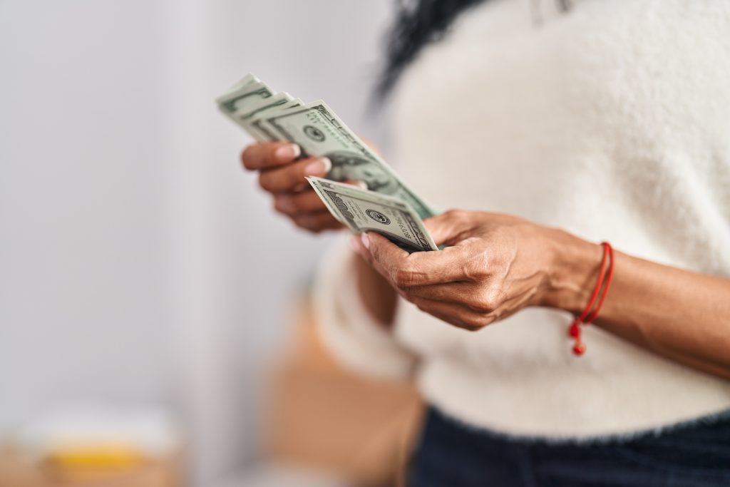 African American Woman Counting Dollars New Home Scaled