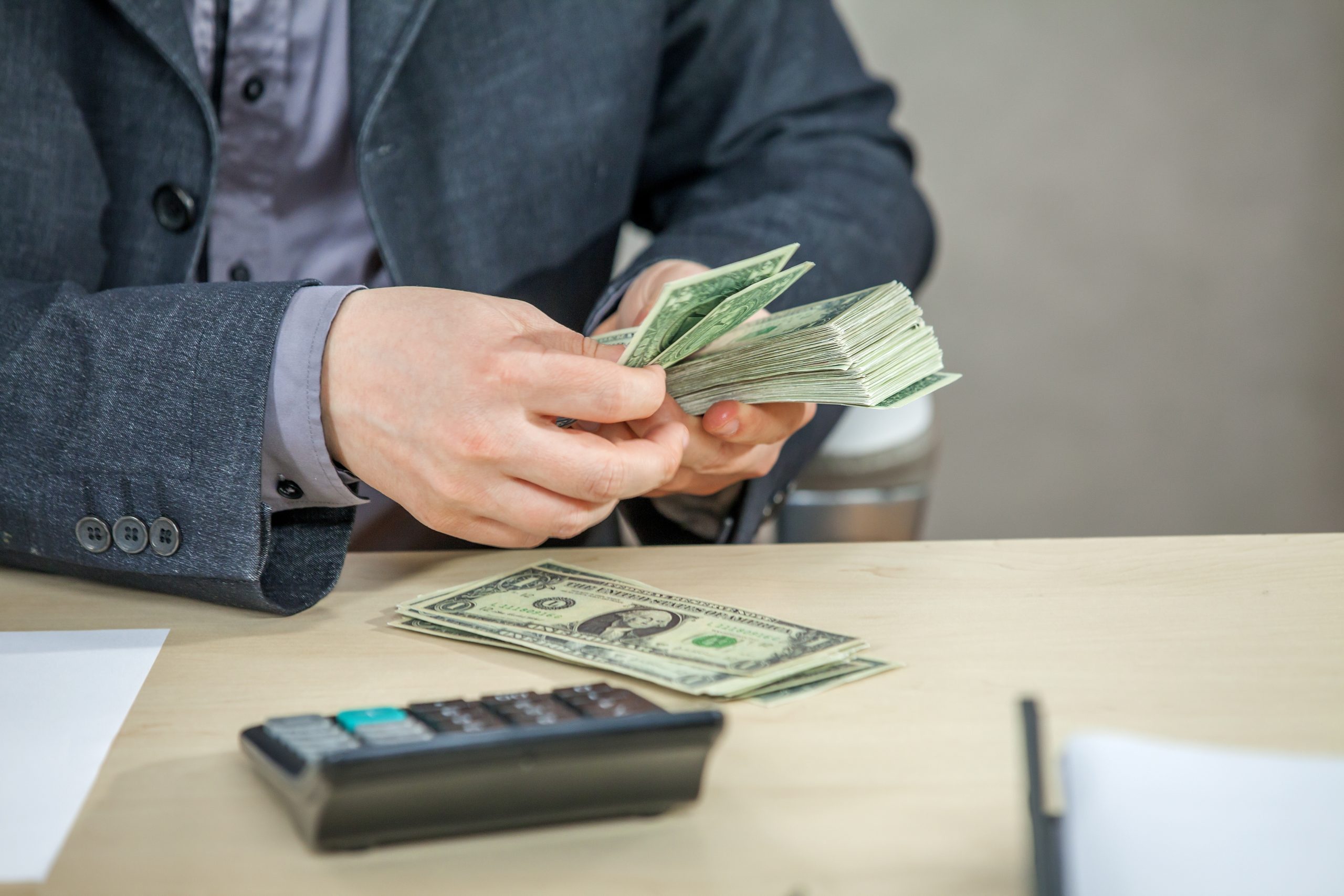 Young Businessman Working From His Office Counting Cash Money 1 Scaled
